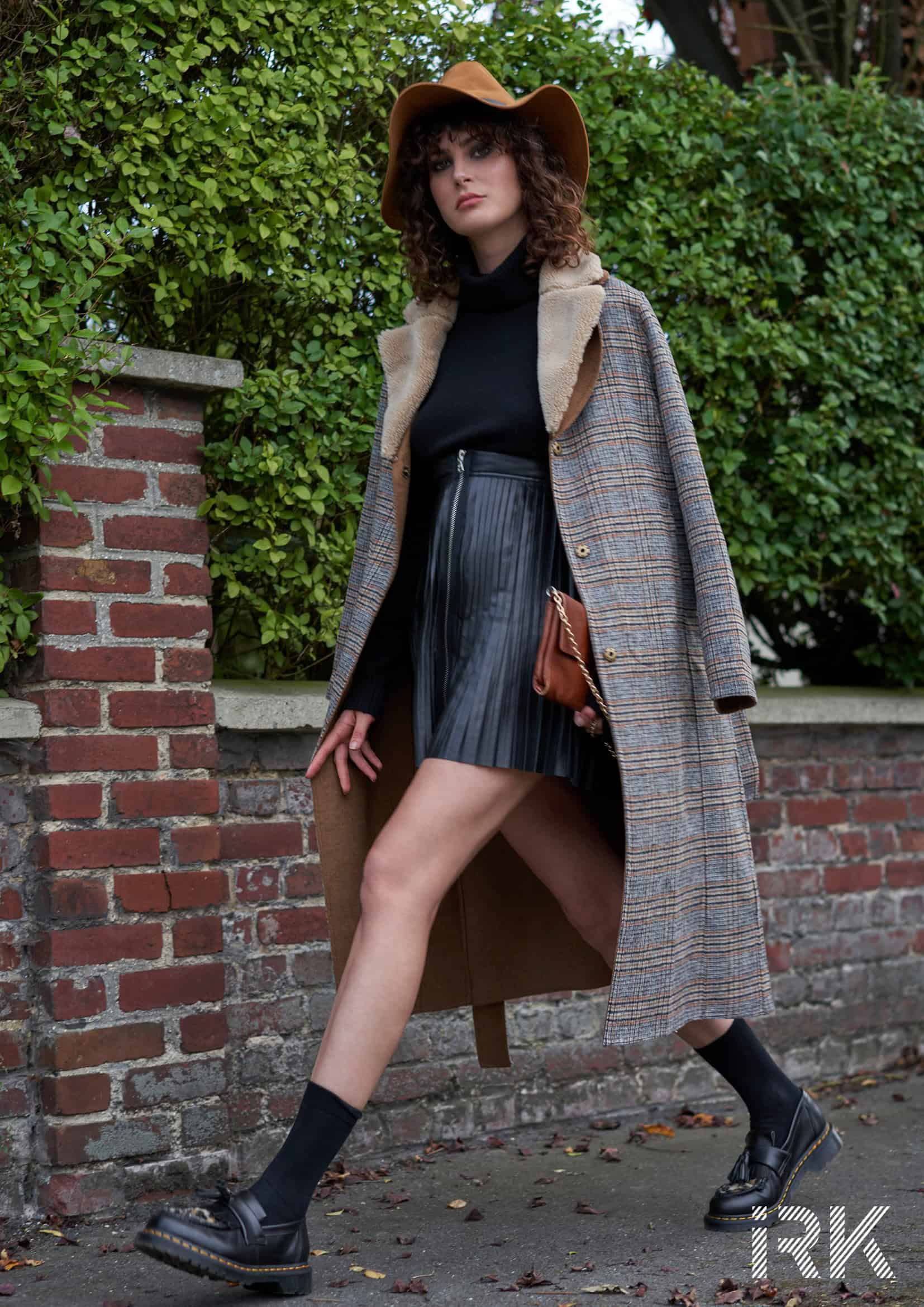 Black cashmere high-neck sweater Barbara Bui, mini pleated leather skirt, Octavio Pizzaro, scottish wool coat Stella Forest, camel-colored leather clutch Sandro, camel-colored felt hat Maison Michèle, black socks Falke, leather and foal moccasins Dr Martens.