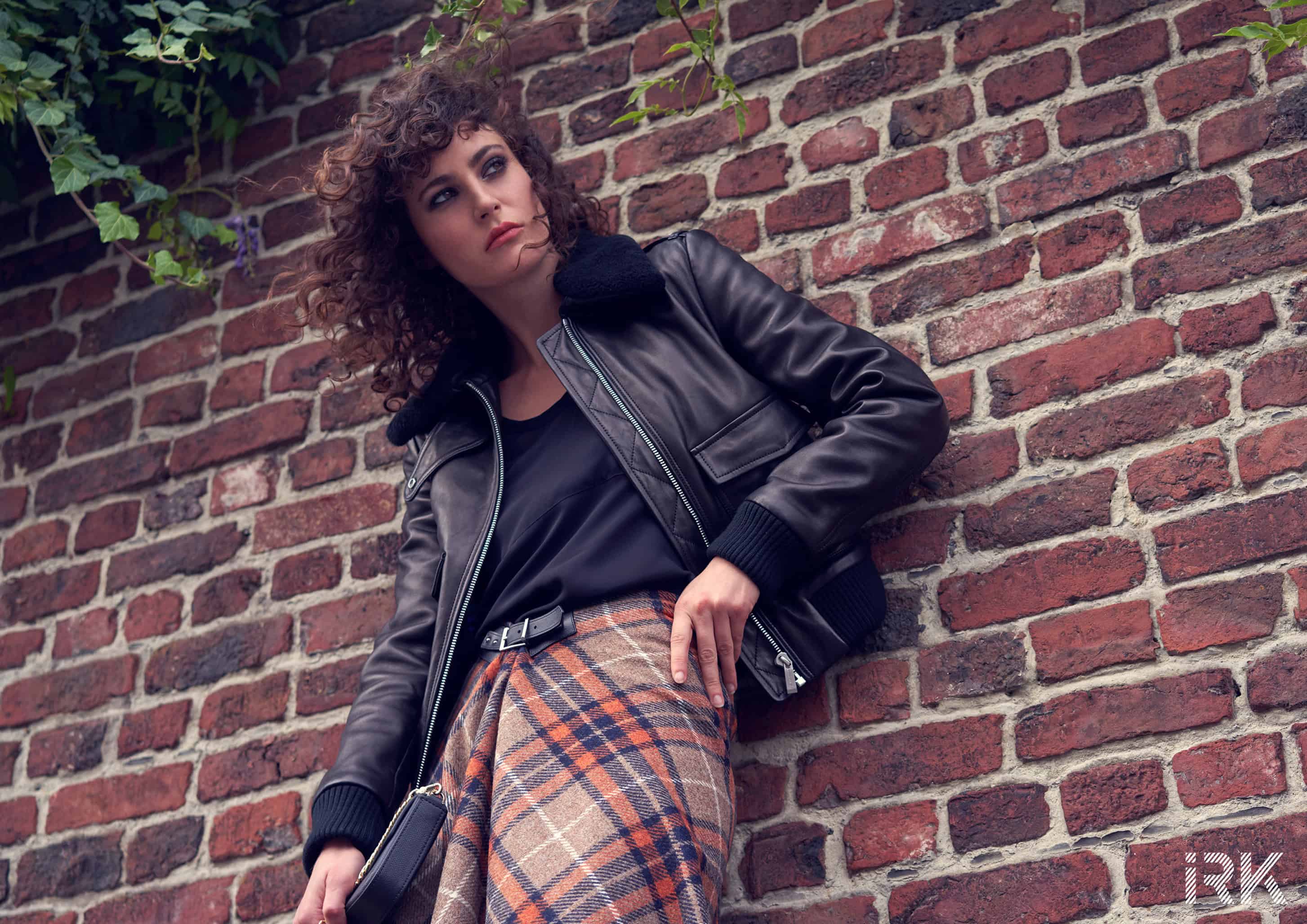 Black cotton t-shirt Petit Bateau, black leather bomber jacket Barbara Bui, asymmetric tartan wool skirt Barbara Bui, "club" clutch bag in sheathed leather with chain Maison Pourchet.