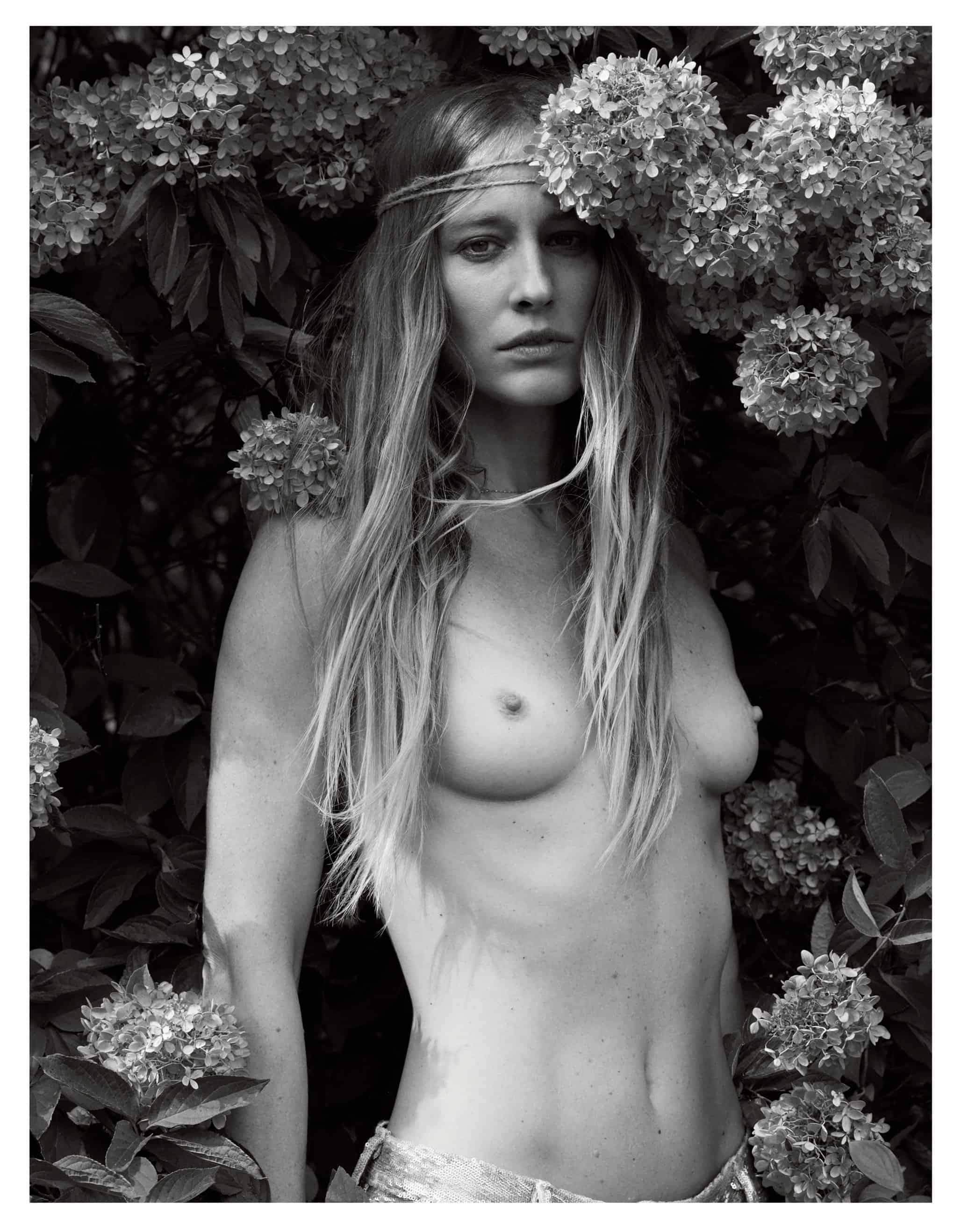 A topless woman amidst flowers