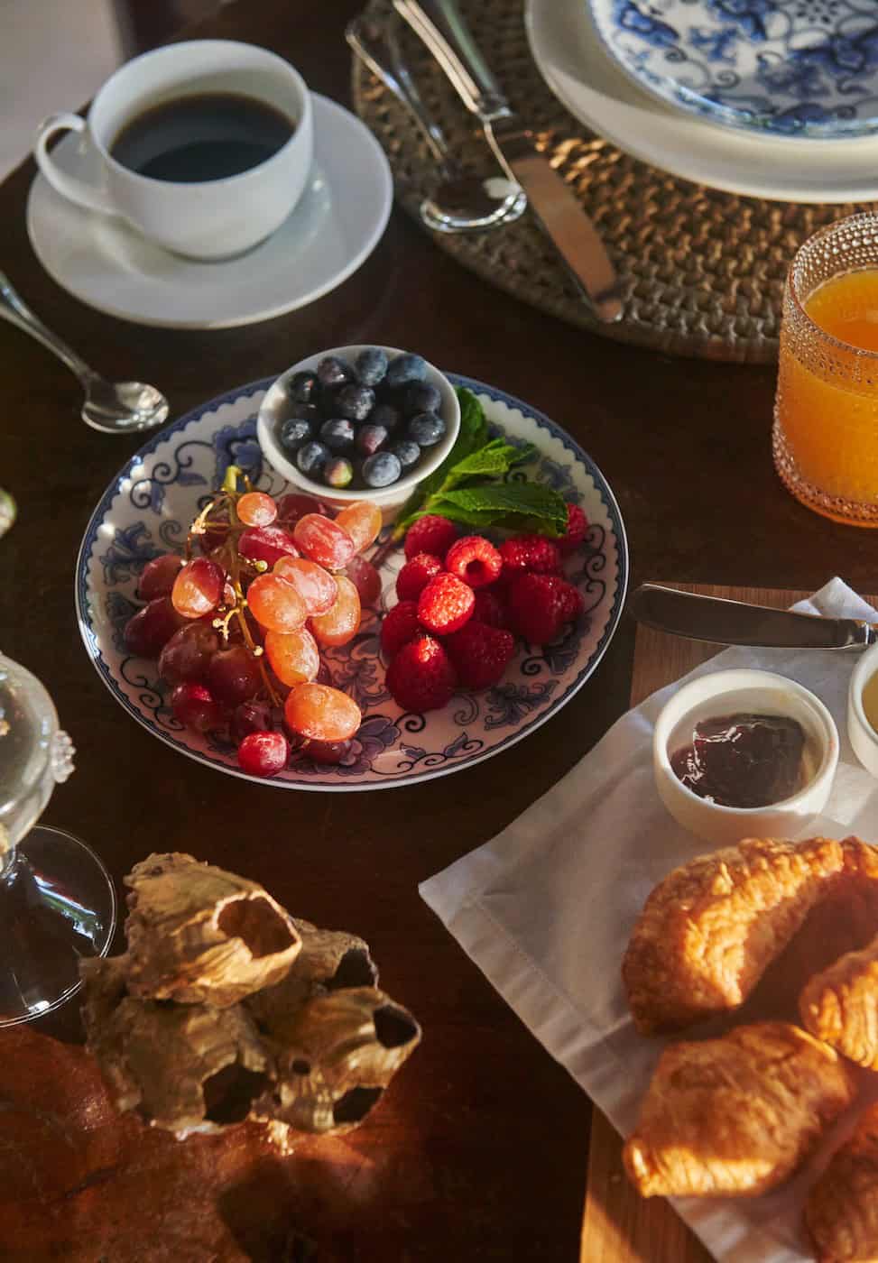 daylight color photograph of breakfast fruit spread and coffee